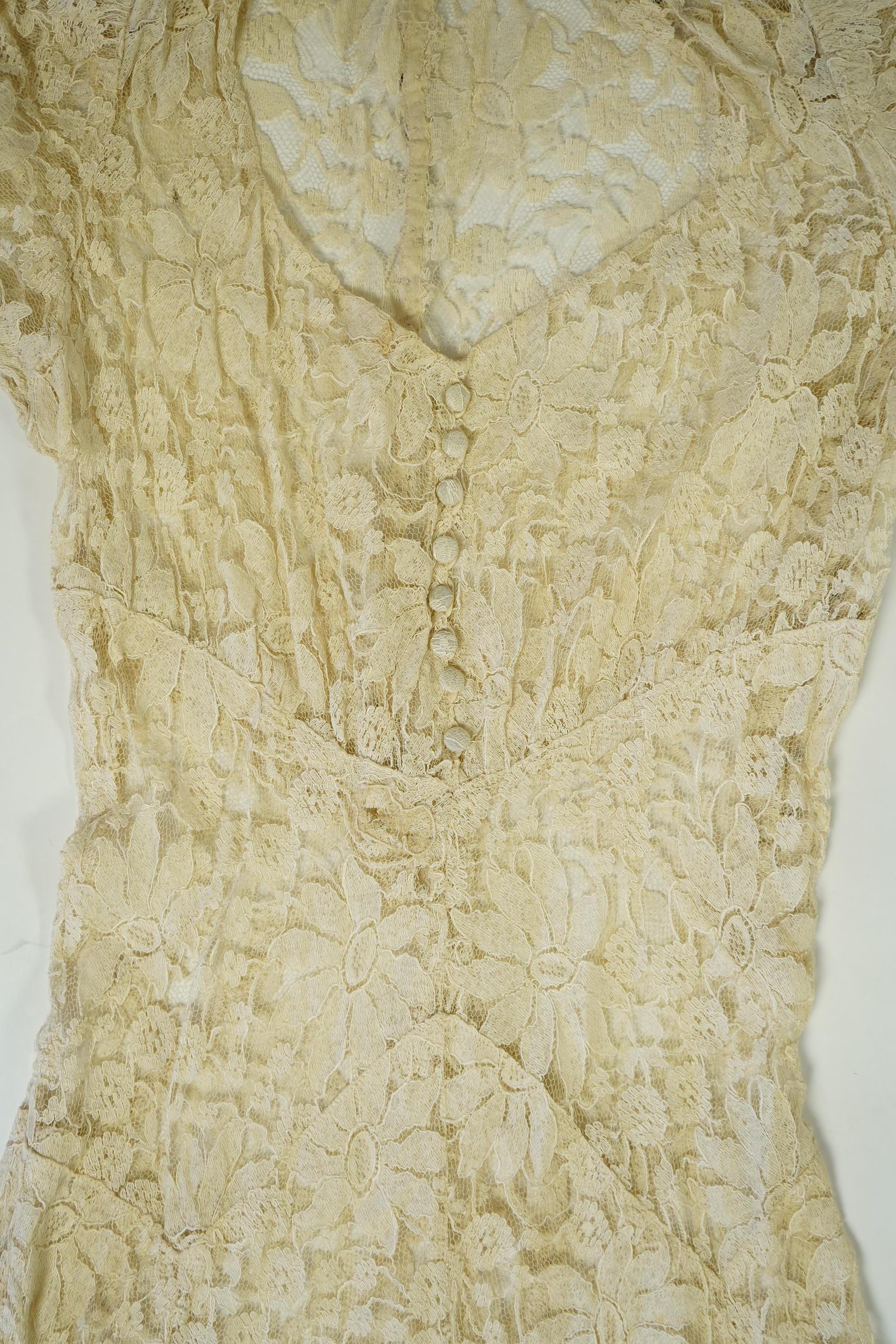 An early 1940's cream cotton lace and taffeta evening dress, with matching taffeta petticoat, possibly worn as a wedding dress., Dress 144cm long. Condition - minor repairs needed to lace in places and laundering to remo